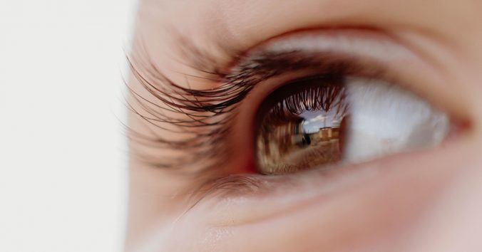 Close-up of eye looking at a house and yard