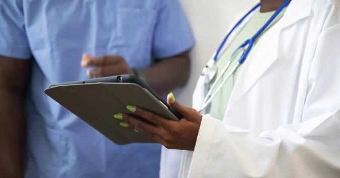 Two caregivers and a digital tablet. Photo: Nappy, from Unsplash.